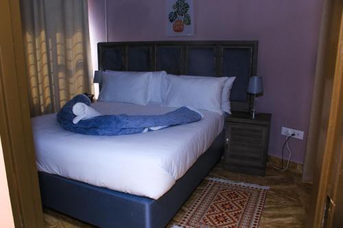 a bedroom with a bed with a blue blanket on it at Masiyabundu Guest House in Gaborone