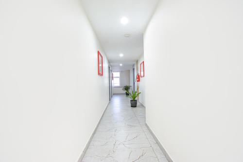 an empty hallway with white walls and a plant in a pot at Fabhotel Unnam- Nr Amazon Hyderabad Campus, Financial District, Gachibowli in Hyderabad