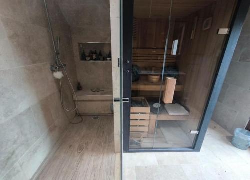 une douche avec une porte vitrée dans une salle de bain dans l'établissement La villa du manege, à La Celle-sous-Gouzon