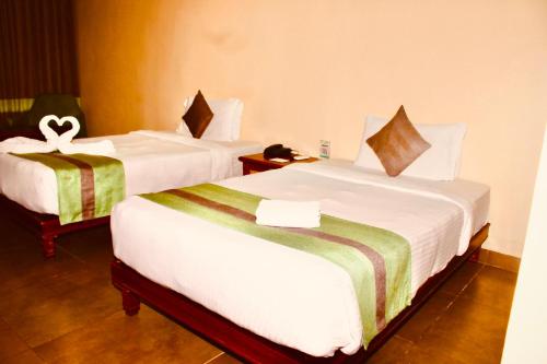 a hotel room with two beds with white sheets at THE CENT HOTEL in Hyderabad