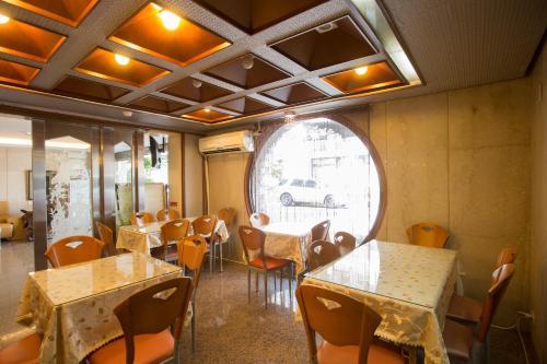 台北的住宿－鳳凰閣溫泉飯店，一间带桌椅的用餐室和窗户。