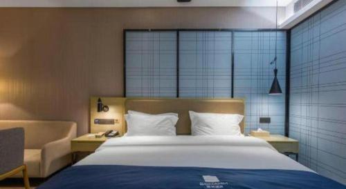 a bedroom with a large bed and a couch at Echarm Hotel Xiangyang Erqi in Xiangyang