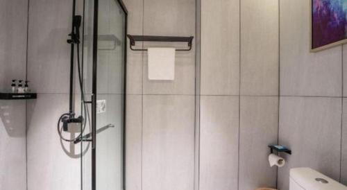a shower with a glass door in a bathroom at Echarm Hotel Xiangyang Erqi in Xiangyang