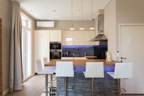 a kitchen with white cabinets and a table and chairs at Neingam in Cannes