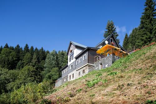a house on top of a hill with a crane at Horská chata Skácelka in Rokytnice nad Jizerou