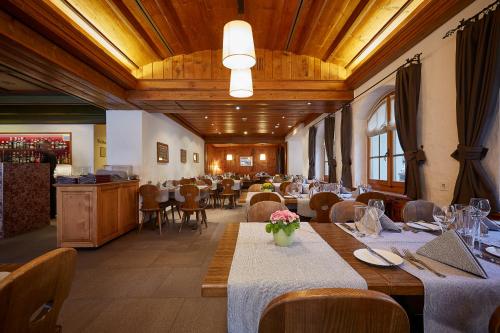 ein Esszimmer mit Tischen und Stühlen in einem Restaurant in der Unterkunft Hotel Landhaus in Gstaad