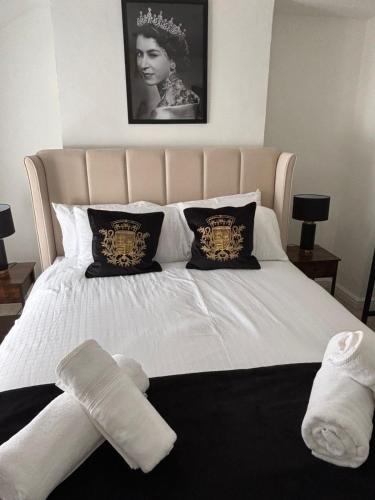 a bed with white sheets and pillows on it at Corner Cottage in Derby