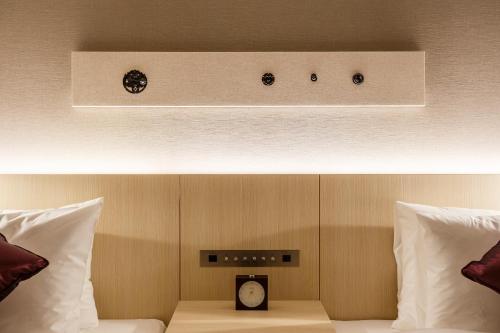 a bed with a clock sitting on top of it at Hotel Vista Sendai in Sendai