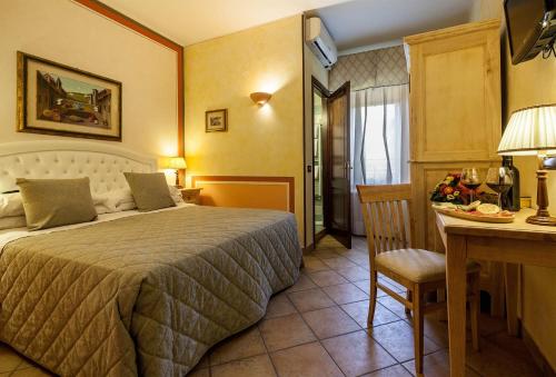 a bedroom with a bed and a table and a desk at Il Melograno Agriturismo & SPA in Pianello