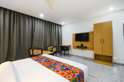 a hotel room with a bed and a tv at Fabhotel Unnam- Nr Amazon Hyderabad Campus, Financial District, Gachibowli in Hyderabad