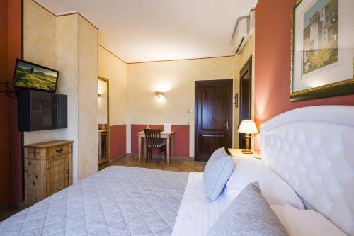 a bedroom with a white bed and a table at Il Melograno Agriturismo & SPA in Pianello