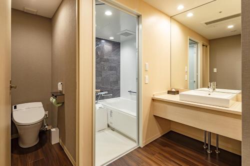 a bathroom with a toilet and a sink and a shower at Hotel Vista Sendai in Sendai