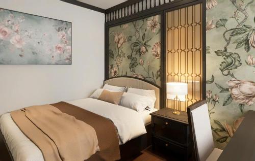 a bedroom with a bed with floral wallpaper at The Dahlia Hotel & Apartments in Hanoi