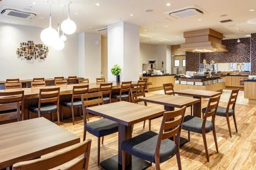 a restaurant with wooden tables and chairs at Hotel Vista Sendai in Sendai