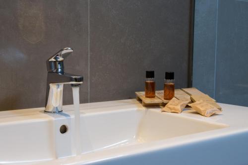 a bathroom sink with a faucet and a mirror at Toscana Ambassador in Poggibonsi