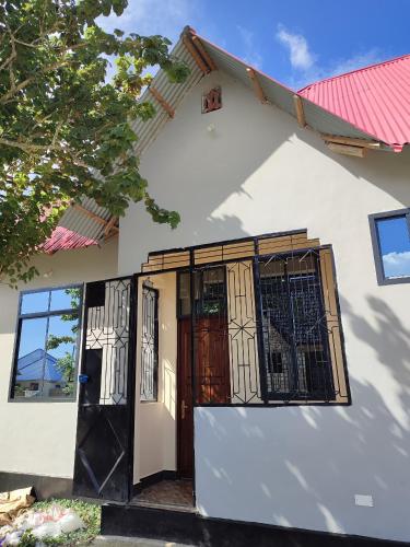 a white house with a door and a window at Nearby fumba joy in Dambani