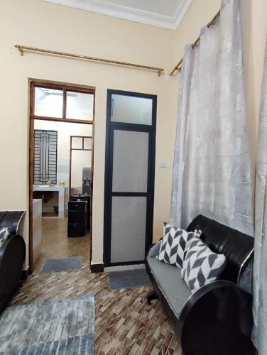 a living room with a couch and a glass door at Nearby fumba joy in Dambani