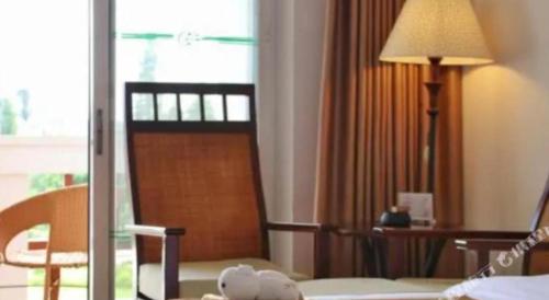 a hotel room with a teddy bear sitting on a bed at Kunming Dianchi Garden Hotel & Spa in Kunming
