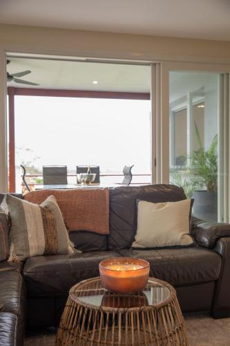 a living room with a brown couch and a table at Sapphire Magic 1B in Urunga
