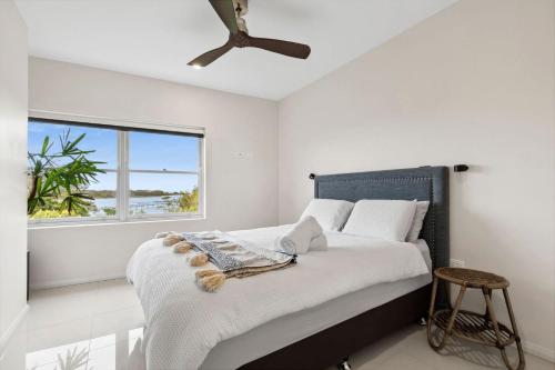 a bedroom with a bed with a large window at Sapphire Magic 1B in Urunga