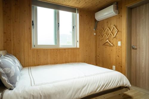 a small bedroom with a bed and a window at 오대산 달빛펜션 Odaesan Moonlight Pension in Pyeongchang 