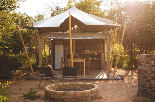 a tent with chairs and a table in a yard at The Leadwood Safari Camp in Dinokeng Game Reserve