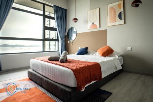 a bedroom with a bed and a large window at Jesselton Quay by Pinstay in Kota Kinabalu