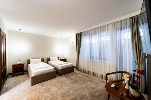 a hotel room with two beds and a window at Hotel AmaDeus in Focşani