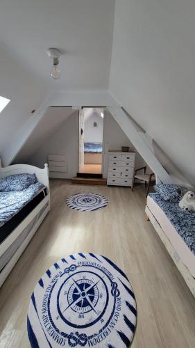 Cette chambre mansardée comprend 2 lits et un tapis. dans l'établissement Maison cosy à 12 mns du Touquet, nature & détente, à Saint-Josse