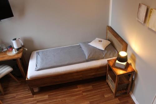 a small bed in a room with a table at ARTHOTEL Herrsching in Herrsching am Ammersee
