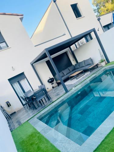 une piscine devant une maison dans l'établissement Villa cosy 10 min de Montpellier, à Saussan