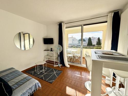 une chambre avec un lit et une grande fenêtre dans l'établissement STUDIO CABINE CLIMATISE AVEC CHAMBRE ALCÔVE, au Cap d'Agde