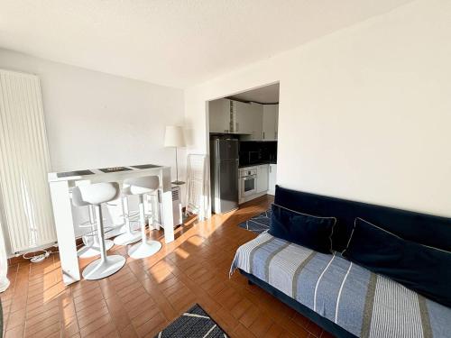 un salon avec un canapé et une cuisine dans l'établissement STUDIO CABINE CLIMATISE AVEC CHAMBRE ALCÔVE, au Cap d'Agde