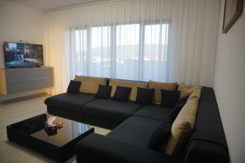 a living room with a couch and a television at Apartament Georgiana in Cristian