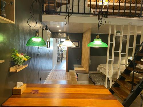 a room with a table and two green lights at 糸旅行蹤 老宅民宿包棟 in Gukeng