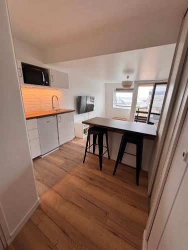 une petite cuisine avec une table au milieu dans l'établissement Studio avec balcon vue mer, à Deauville
