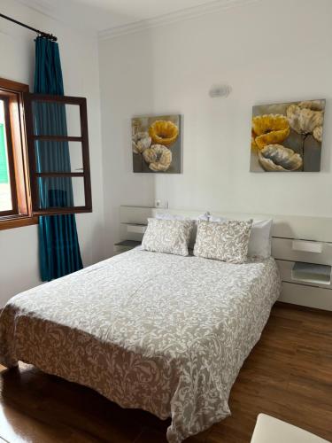 a bedroom with a bed with white sheets and a window at CASA MAREA in Caleta de Caballo