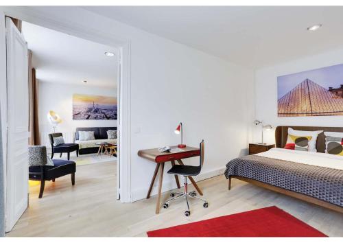 a bedroom with a bed and a desk and a room with a bed at Apartments Paris Centre - At Home Hotel in Paris