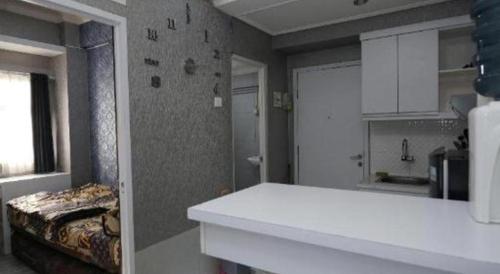 a room with a bed and a white counter top at OYO Living 3091 Apt The Suites Metro By Ananda in Bandung