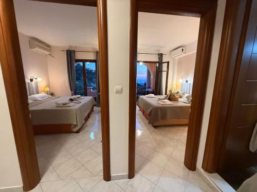 a bedroom with two beds and a mirror at TRAVELLERS BEAUTIFUL ELEN Agios Gordios Sea in Agios Gordios