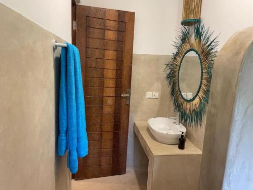 a bathroom with a sink and a mirror at Sand Beach Boutique in Bwejuu