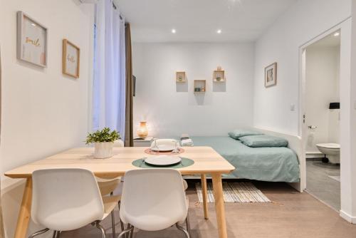une pièce avec une table, des chaises et un lit dans l'établissement Le Mistral a deux pas du vieux port, à Marseille