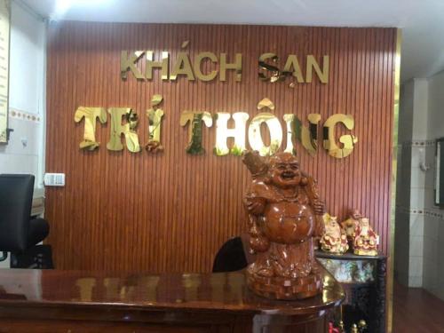 a sign for a store with a statue on a table at Trí Thông Hotel in Ho Chi Minh City