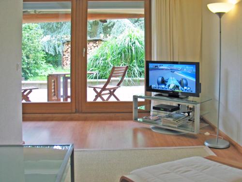 a living room with a television on a table at B&B Hersberg in Hersberg