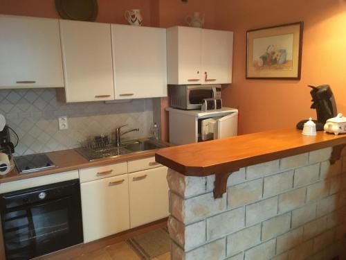 a kitchen with white cabinets and a counter top at Appartement dernier étage, très belle vue - Centre-ville in Vichy