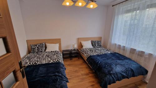 due letti in una stanza con finestra di Apartament z ogródkiem a Ciechocinek