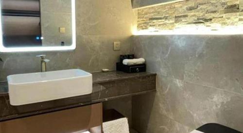 a bathroom with a sink and a mirror at Chaozhou Hotel in Chaozhou