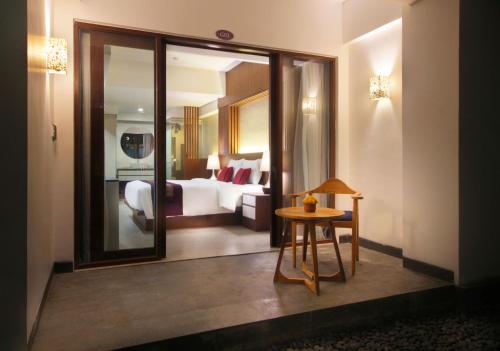 a hotel room with a bed and a table and a mirror at Nadi Hotel Legian in Legian