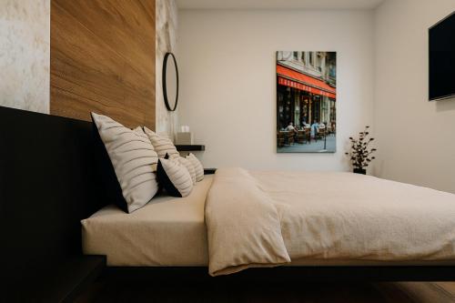 a bedroom with a large bed with white pillows at VELUNA Salzburg One in Salzburg