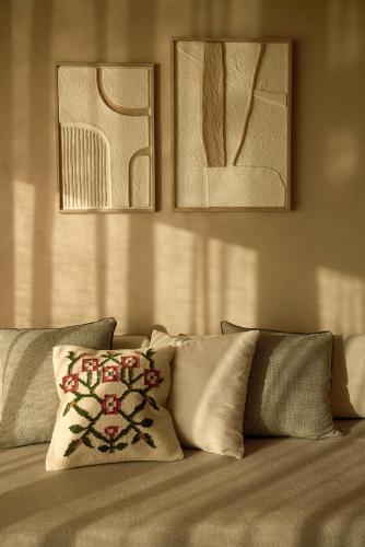a bed with pillows and paintings on the wall at Alkyna Lifestyle Beach Resort - Adults Only in Agios Gordios